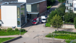 Urban traffic scene in Helsinki with cyclists and vans between residential buildings