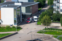 Urban traffic scene in Helsinki with cyclists and vans between residential buildings