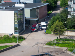 Urban traffic scene in Helsinki with cyclists and vans between residential buildings