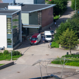 Urban traffic scene in Helsinki with cyclists and vans between residential buildings