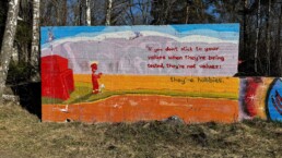 Street art on a concrete wall in Helsinki reading: 